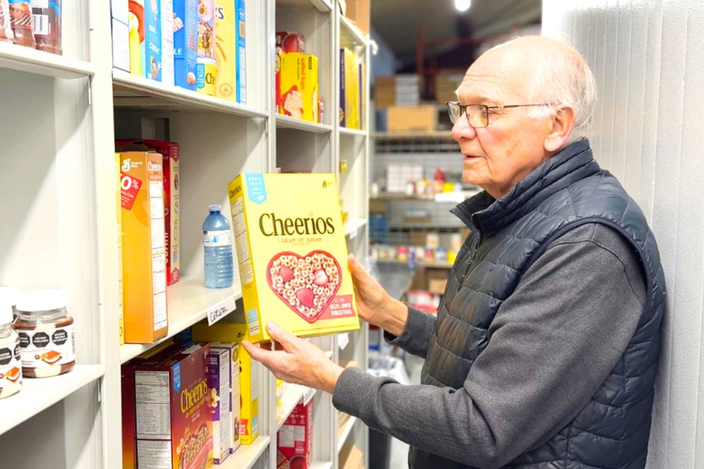 A Harvest Hands volunteer stocking cereal on warehouse shelves
