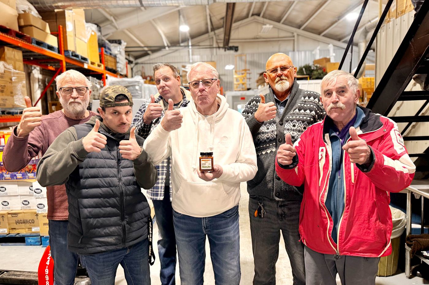 Harvest Hands volunteers giving a thumbs up in the warehouse